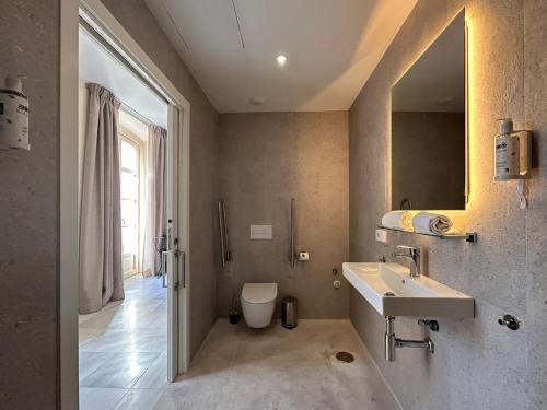 a bathroom with a sink and a toilet and a mirror at Smartr Malaga Centro in Málaga