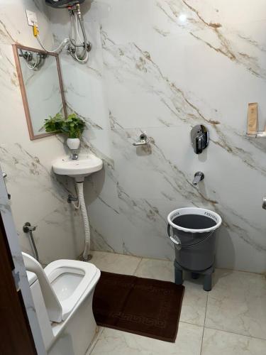 a white bathroom with a toilet and a sink at Hotel Apex Inn Hyderabad Airport in Hyderabad