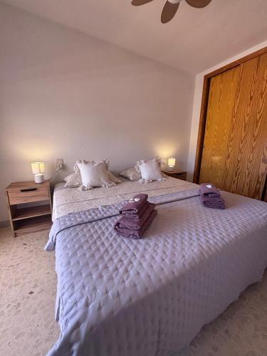 a bedroom with a white bed with towels on it at Terraza Soleada in Puerto de Gandía