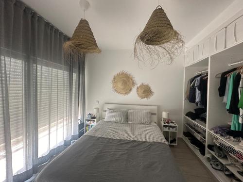 a bedroom with a bed and two hanging baskets at DuMar Beachouse in Salema