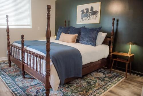 a bedroom with a large bed with blue pillows at The Fox Hunt - A Ground Floor Condo in Southern Pines