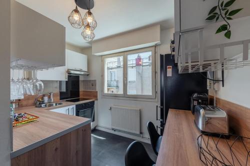 a kitchen with a counter and a sink and a window at Le Stanislas 61 - Spacieux & Cosy in Nancy