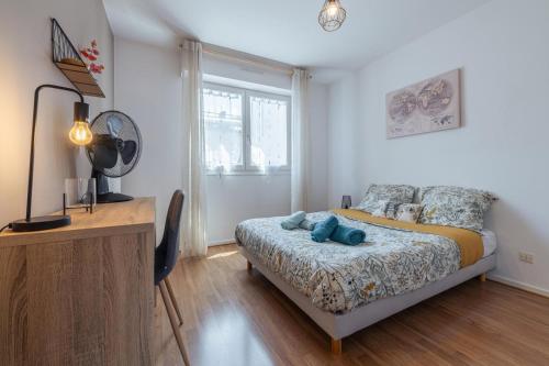 a bedroom with a bed and a desk and a window at Le Stanislas 61 - Spacieux & Cosy in Nancy