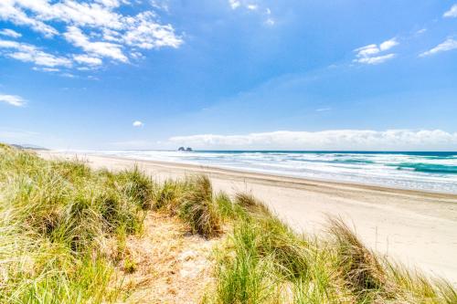 a sandy beach with a view of the ocean at Sea Treasures Inn #101 in Rockaway Beach