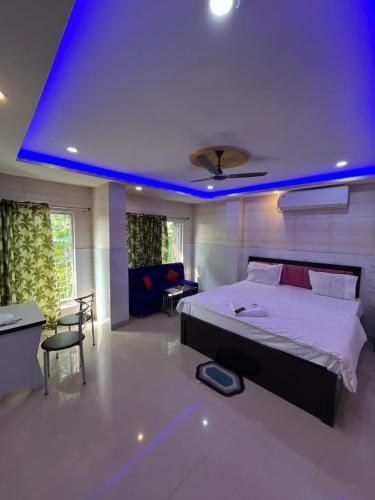 a bedroom with a large bed with a blue ceiling at Top Comfort in Kolkata
