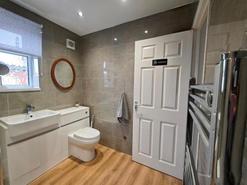 a bathroom with a white toilet and a sink at Spacious 3 Bedroom Home Ample Parking Near Shops in Bridgemary