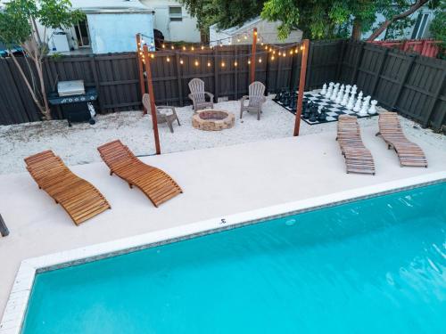 a backyard with a swimming pool with chairs and a table at Hollywood 4BR Home with Private Heated Pool in Hollywood