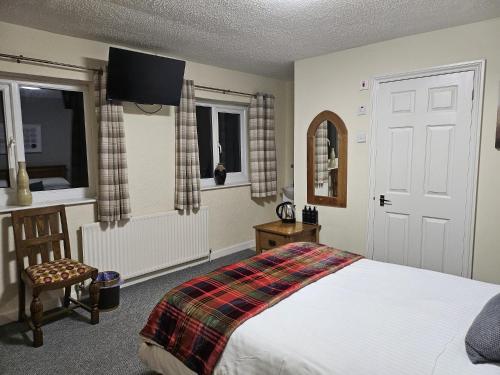 a bedroom with a bed and a tv on the wall at The Rockford Inn in Lynton