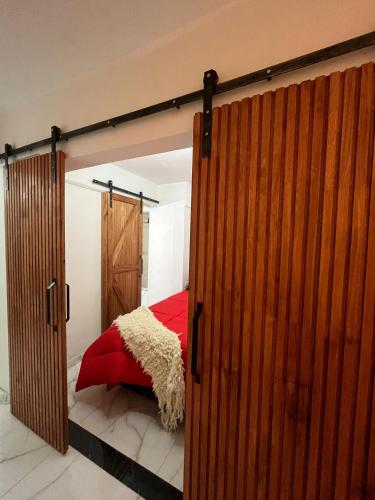 a bedroom with a sliding barn door with a red bed at Vicco in Pinamar