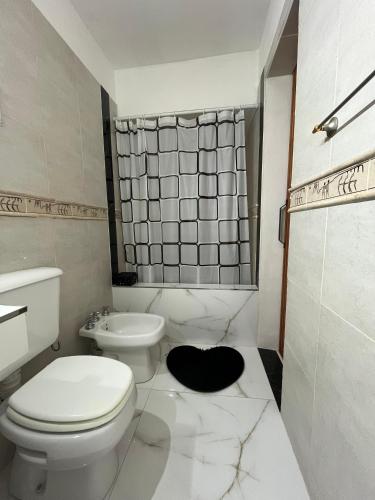 a white bathroom with a toilet and a shower at Vicco in Pinamar