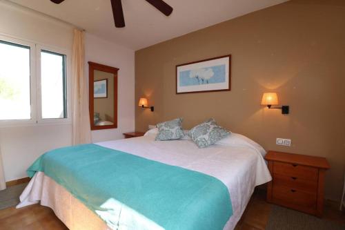 a bedroom with a large bed with two pillows at Apartamento Complejo Pinimar in Port d'Addaia