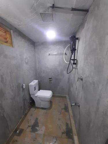 a bathroom with a toilet in a room at KADUPUL Hiriketiya in Hiriketiya