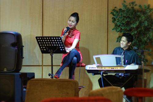 a woman sitting in a chair with a microphone at Rocky Plaza Hotel Padang in Padang