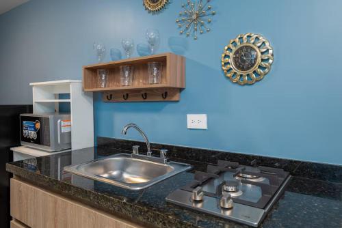 a kitchen with a sink and a stove at Leb'Den Executive Suites in Cali