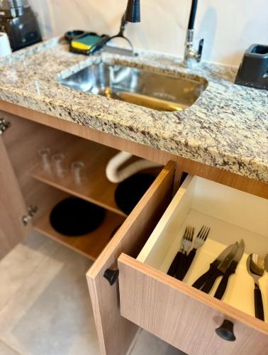 a kitchen counter with a sink and a drawer at Onda Studios Apê Completo - Vista Linda e Sesc Bertioga - Ar Condicionado in Bertioga