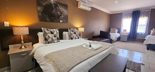 a bedroom with a large bed and a living room at Lion Lodge in Bloemfontein