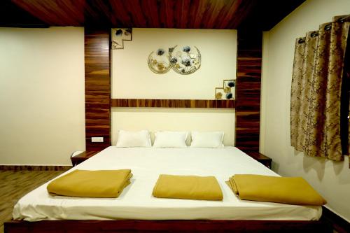 a bedroom with a large white bed with yellow pillows at Suryavan Holidays in Chinchavli