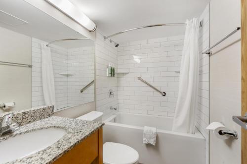 a bathroom with a tub and a toilet and a sink at Best Western Grande Prairie in Grande Prairie