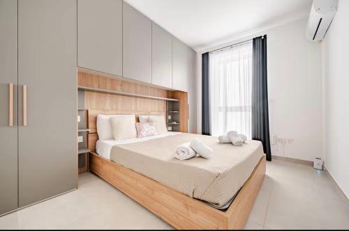 a bedroom with a large bed with two towels on it at Gzira Getaway in Il-Gżira