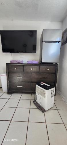 a room with a tv and a microwave and a tvicterictericterictericter at Butterfly Ranch in St. Petersburg