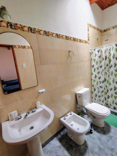 a bathroom with a sink and a toilet and a mirror at La Colorada Hostal in Tilcara
