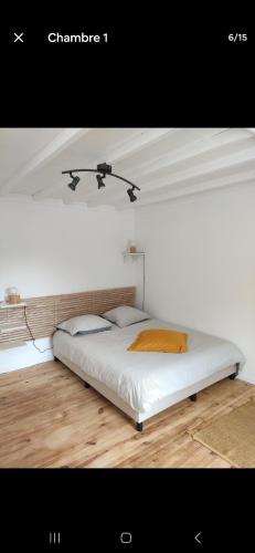 a white bed in a room with a ceiling at Chez madame Hulotte in Saint-Nazaire