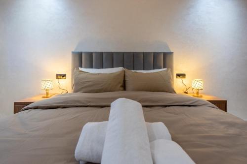 a bedroom with a large bed with two lamps at Magnificent apartment 10 in Casablanca