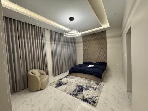 a bedroom with a bed and a chair at Faj Court Family only bed and breakfast in Ajman