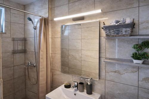 a bathroom with a sink and a shower with a mirror at Secret Garden Hotel in Maleme