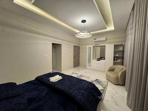 a bedroom with a bed and a chair in it at Faj Court Family only bed and breakfast in Ajman