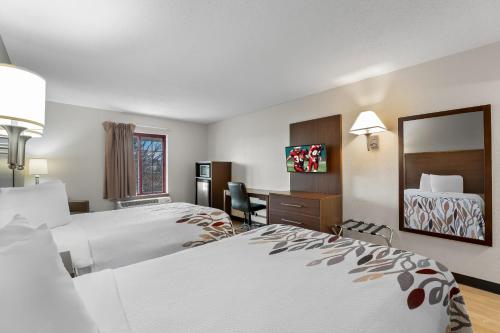 a hotel room with two beds and a desk at Red Roof Inn Lancaster in Lancaster
