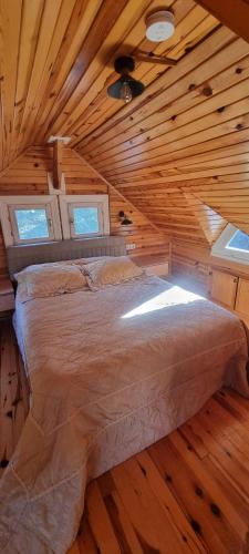 a bed in a room with a wooden ceiling at Özer hızarcıoglu in Talipler