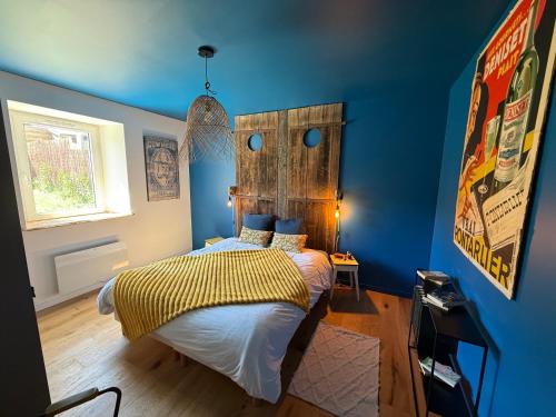 a bedroom with a bed with a blue wall at La Grange d'Annalys in Granges-Narboz
