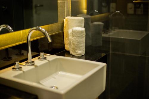 a white sink in a bathroom with a mirror at ibis Styles Rondonopolis in Rondonópolis