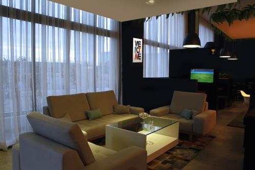 a living room with a couch and chairs and a tv at ibis Styles Rondonopolis in Rondonópolis