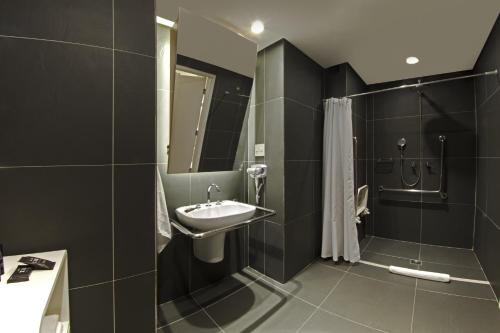 a bathroom with a sink and a shower at ibis Styles Rondonopolis in Rondonópolis