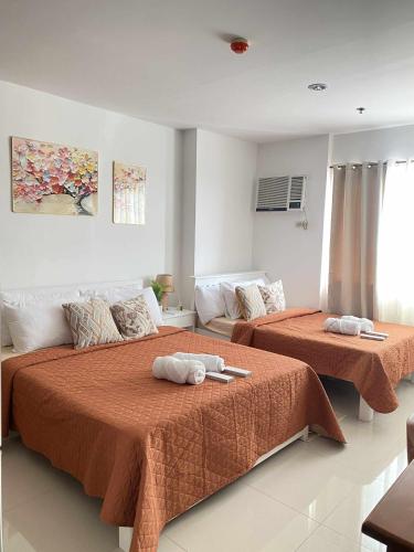 a bedroom with two beds with towels on them at Kozzy Loft Sitari Condominium in Bacolod