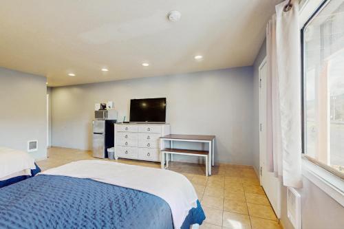 a bedroom with a bed and a flat screen tv at Sea Treasures Inn #102 in Rockaway Beach