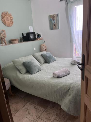 a bed with pillows on it in a bedroom at Maison d'hôtes Bastide St Victor à 2,5 kilomètres de Lourmarin in Puyvert