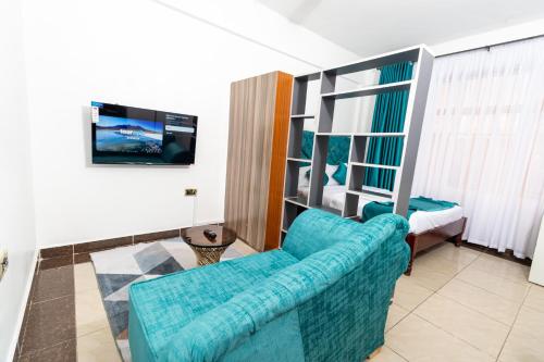 a living room with a blue couch and a bedroom at MIG Studios in Nakuru
