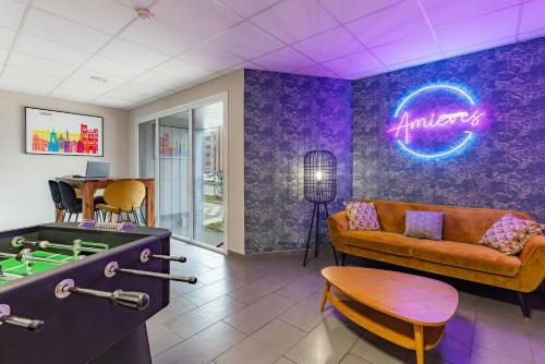 a living room with a couch and a pool table at Appart'City Confort Amiens Gare in Amiens