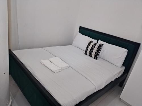 a bed with two pillows and two towels on it at Magenche in Ongata Rongai 