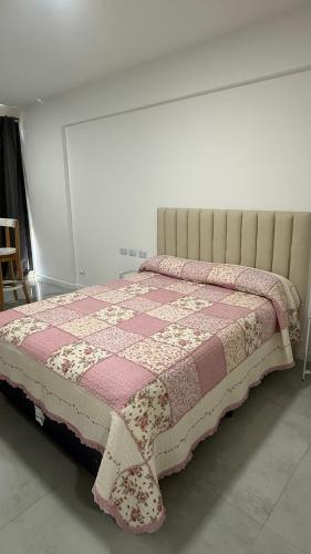 a bedroom with a bed with a pink and white quilt at Brickell 3A in Tigre