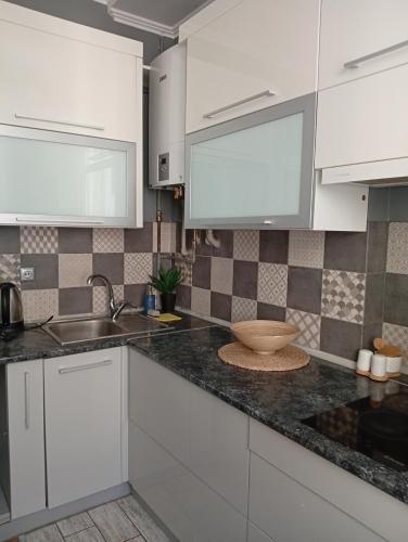 a kitchen with white cabinets and a sink at Gray in Ternopil