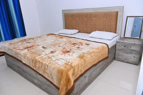 a bedroom with a large bed with a wooden headboard at Nirmala Garden in Bamiana