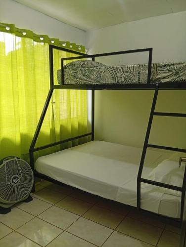 two bunk beds in a room with a fan at Apartamentos GoZu # 2 in Puerto Viejo