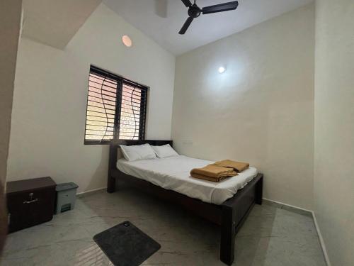 a bedroom with a bed with a ceiling fan at Athityam Home Stay in Honāvar