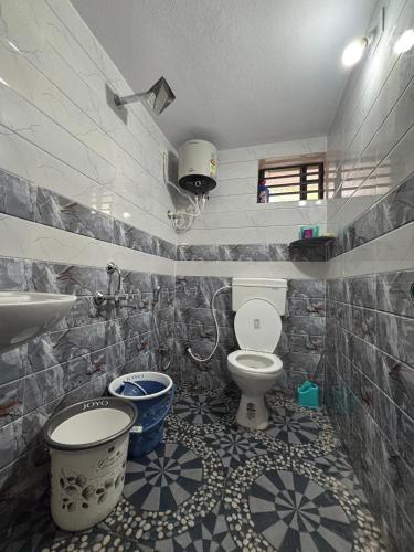 a bathroom with a toilet and a sink at Athityam Home Stay in Honāvar