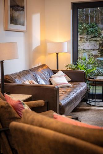 a living room with a leather couch and a table at Downshire Haven in Holywood