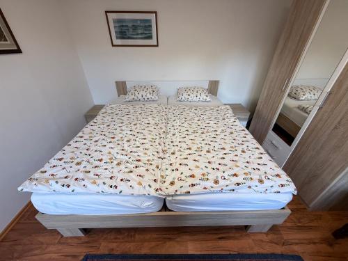 a bed in a bedroom with a bedspread with dolphins on it at Útulný apartmán v Jizerkách in Hejnice